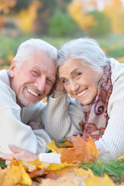 Foto feliz casal sênior deitado no parque