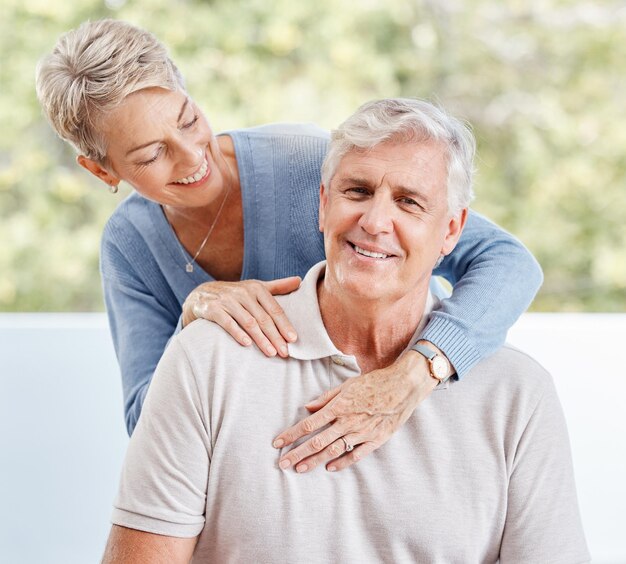 Feliz casal sênior se abraça em casa e apartamento enquanto relaxa no lounge para cuidar do amor e se aposentar juntos na Austrália Sorriso de felicidade e velho, mulher e as pessoas aproveitam o tempo de qualidade