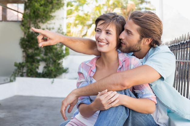 Feliz casal sentado e abraçado