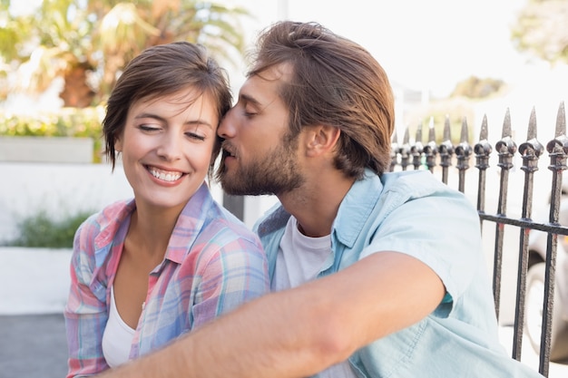 Feliz casal sentado e abraçado