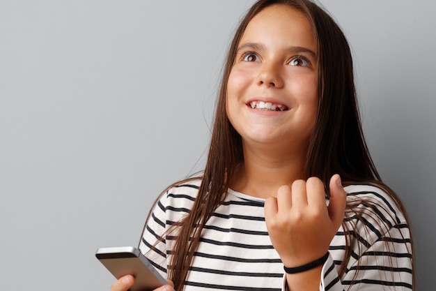 Feliz casual niña mirando su teléfono