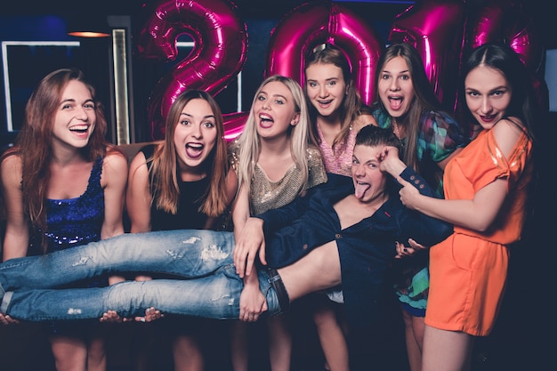 Feliz celebración de año nuevo. Selfie de amigos divertidos. Un hombre en compañía de chicas en club nocturno, fondo divertido, felicidad, concepto de recogida