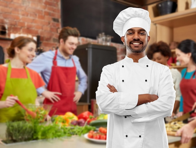 Foto feliz chef indio en toque en la clase de cocina