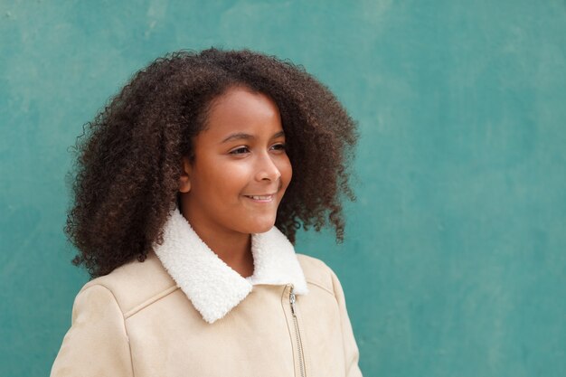 Feliz chica afroamericana con pelo afro sobre un fondo verde