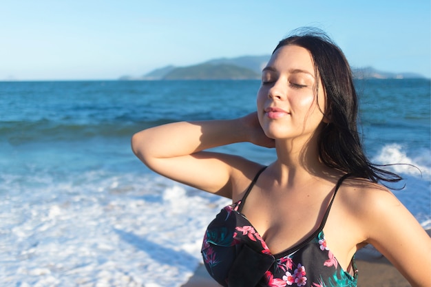 Feliz chica alegre relajada disfrutando del buen clima en una playa al atardecer