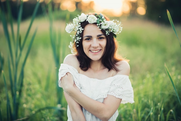 Feliz chica atractiva en vestido blanco sonriendo felizmente