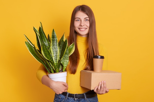 Feliz chica guapa vistiendo ropa casual de pie aislado sobre estudio amarillo