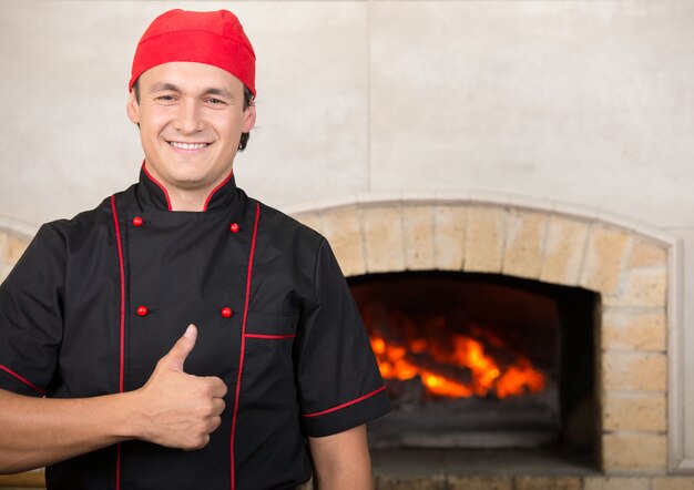 Foto feliz cocinero atractivo frente al horno.