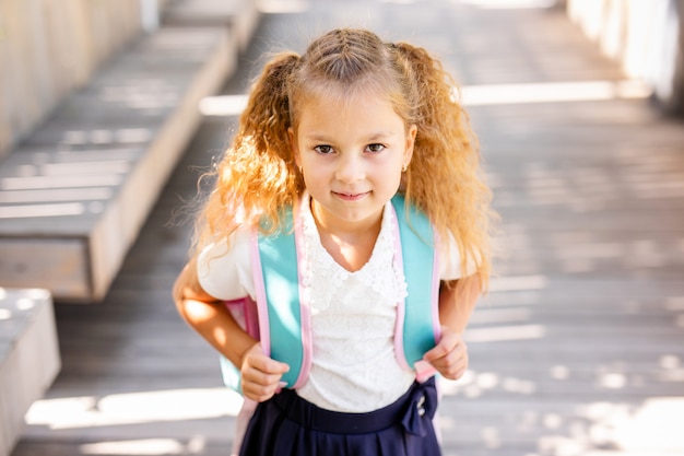 Feliz colegiala con manzana. Regreso a la escuela al aire libre