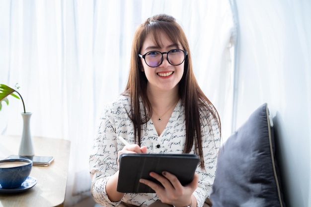 Feliz com os freelancers asiáticos, mulheres de negócios casuais trabalhando com draw ou anotando no digital