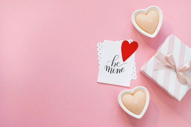 Feliz composição do dia dos namorados. Maquete de cartão em branco, caixas de presente, corações vermelhos, confetes em fundo rosa