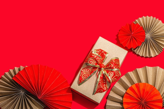 Feliz conceito de presente de Ano Novo Chinês Fãs de papel de estilo asiático oriental decoração tradicional em fundo vermelho conceito mínimo plano vista de cima