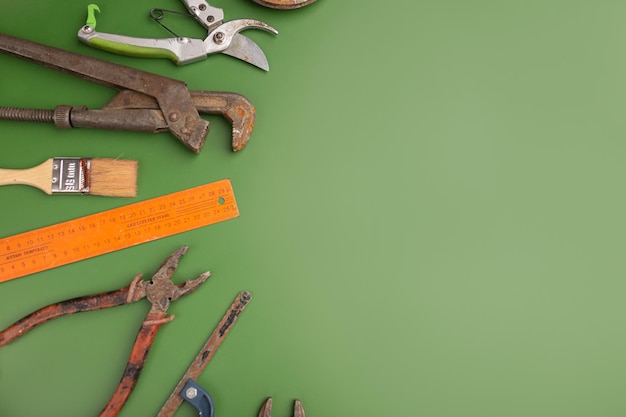 Feliz conceito do dia do trabalho Diferentes ferramentas de construção em fundo verde com espaço de cópia para texto