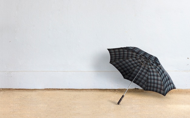 Feliz concepto de día lluvioso. paraguas con fondo de pared de ladrillo