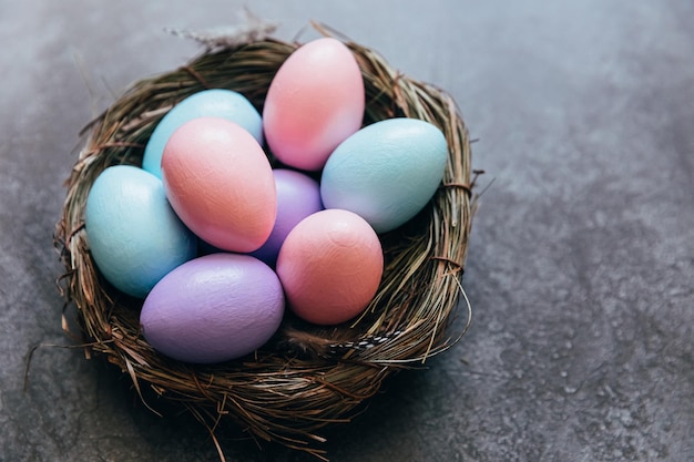 Feliz concepto de Pascua preparación para las vacaciones coloridos pastel decorados huevos de Pascua en nido en grunge