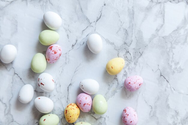 Feliz concepto de Pascua. Preparación para vacaciones. Pascua pastel dulces chocolate huevos dulces sobre fondo de mármol gris de moda. Minimalismo simple, plano, vista superior, espacio de copia.