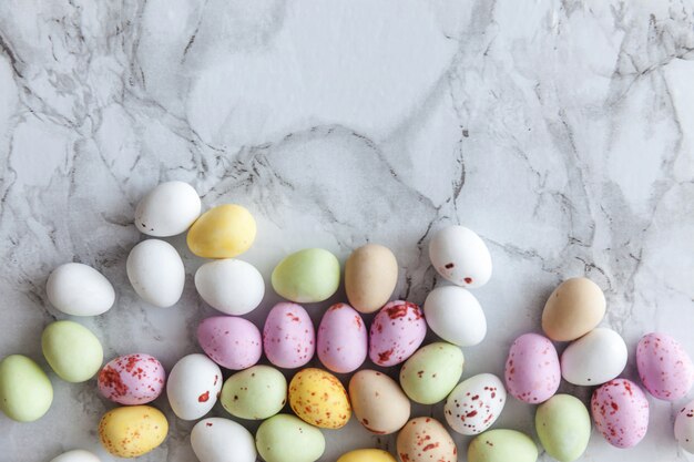 Feliz concepto de Pascua. Preparación para vacaciones. Pastel de Pascua dulces huevos de chocolate dulces en mármol gris de moda. Minimalismo simple, plano, vista superior, espacio de copia.