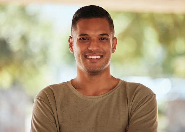 Foto feliz confiante e retrato de um homem bonito na natureza para exercícios físicos e treino motivação felicidade e rosto de um atleta com sorriso de confiança e positividade sobre treinamento esportivo