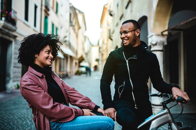 Feliz y contento pareja étnica negra sentada en bicicleta.