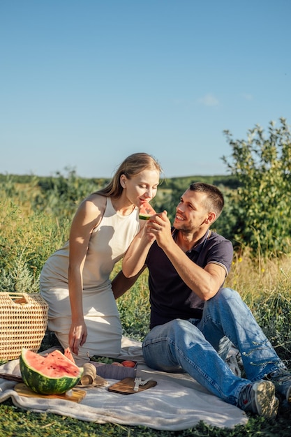 Feliz coqueteo amorosa pareja besándose y teniendo una cita al aire libre pareja joven en un picnic de verano con