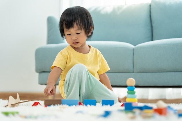 Feliz criança asiática brincando e aprendendo blocos de brinquedo, as crianças estão muito felizes e animadas em casa, a criança se diverte muito jogando atividades, desenvolvimento, transtorno de déficit de atenção e hiperatividade