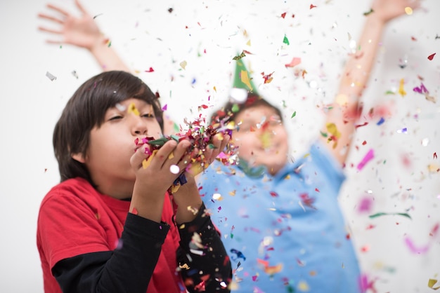 Feliz, crianças, celebrando, partido, com, soprando, confetti