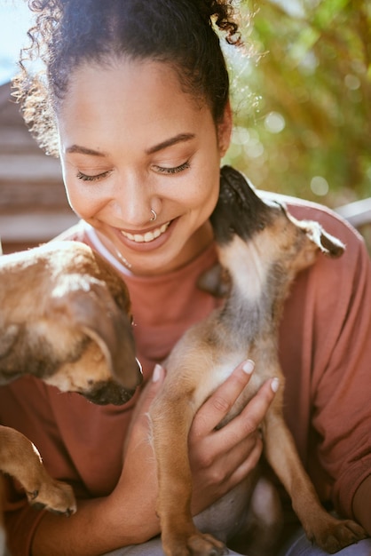 Foto feliz cuidado e menina brincando com cachorros no centro de adoção de animais com sorriso animado segurando o cachorrinho felicidade mulher negra e lealdade de animais de estimação adotivos com lambida carinhosa para vínculo e confiança