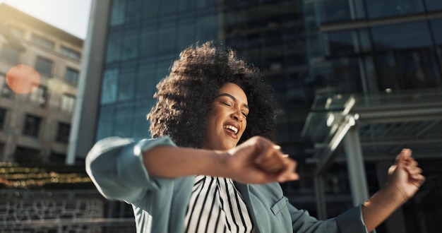 Foto feliz dança e mulher de negócios na cidade com celebração de promoção de emprego e atitude positiva sorriso entusiasmado e profissional jovem mulher se mudando para boas notícias com carreira na cidade urbana