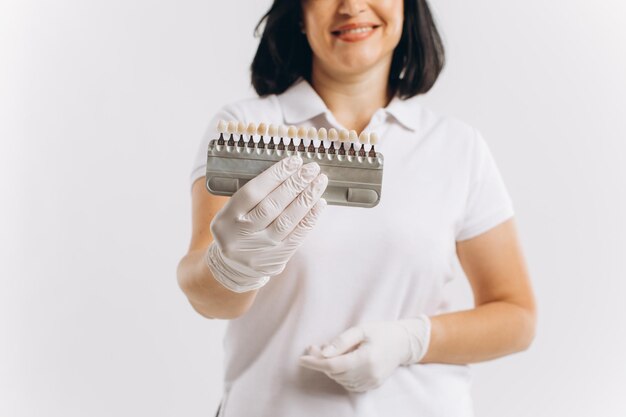 Feliz dentista médico mujer mostrando maqueta de implantes