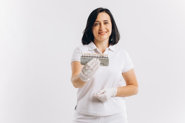 Feliz dentista médico mujer mostrando maqueta de implantes