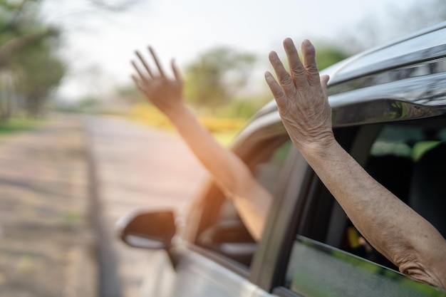 Feliz desfrute e liberdade em viagem de viagem com a mão da mãe levantada fora do carro da janela nas férias de verão