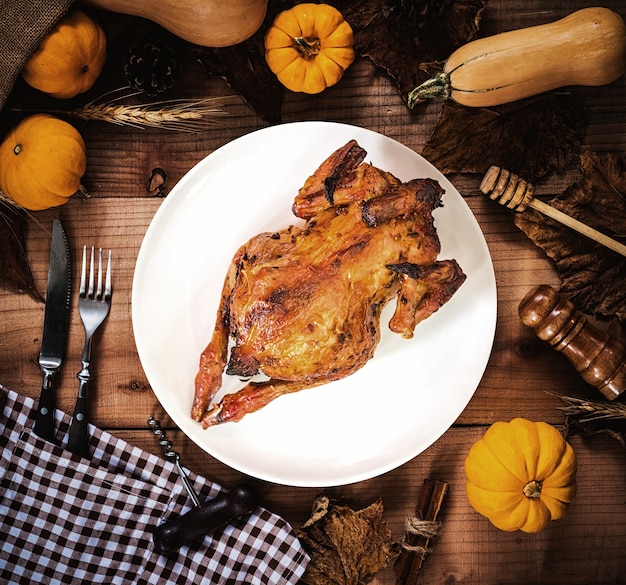 Feliz día de acción de gracias. Pollo asado y pavo en plato blanco con decoración de calabaza.