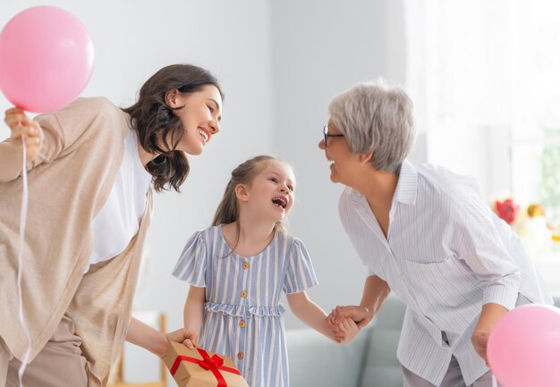 Feliz dia da mulher Mãe de criança e vovó com balões de ar Vovó mãe e menina sorrindo