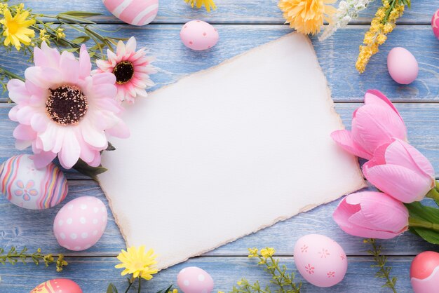 Feliz dia da páscoa com ovos cor de rosa e decoração de flores em madeira