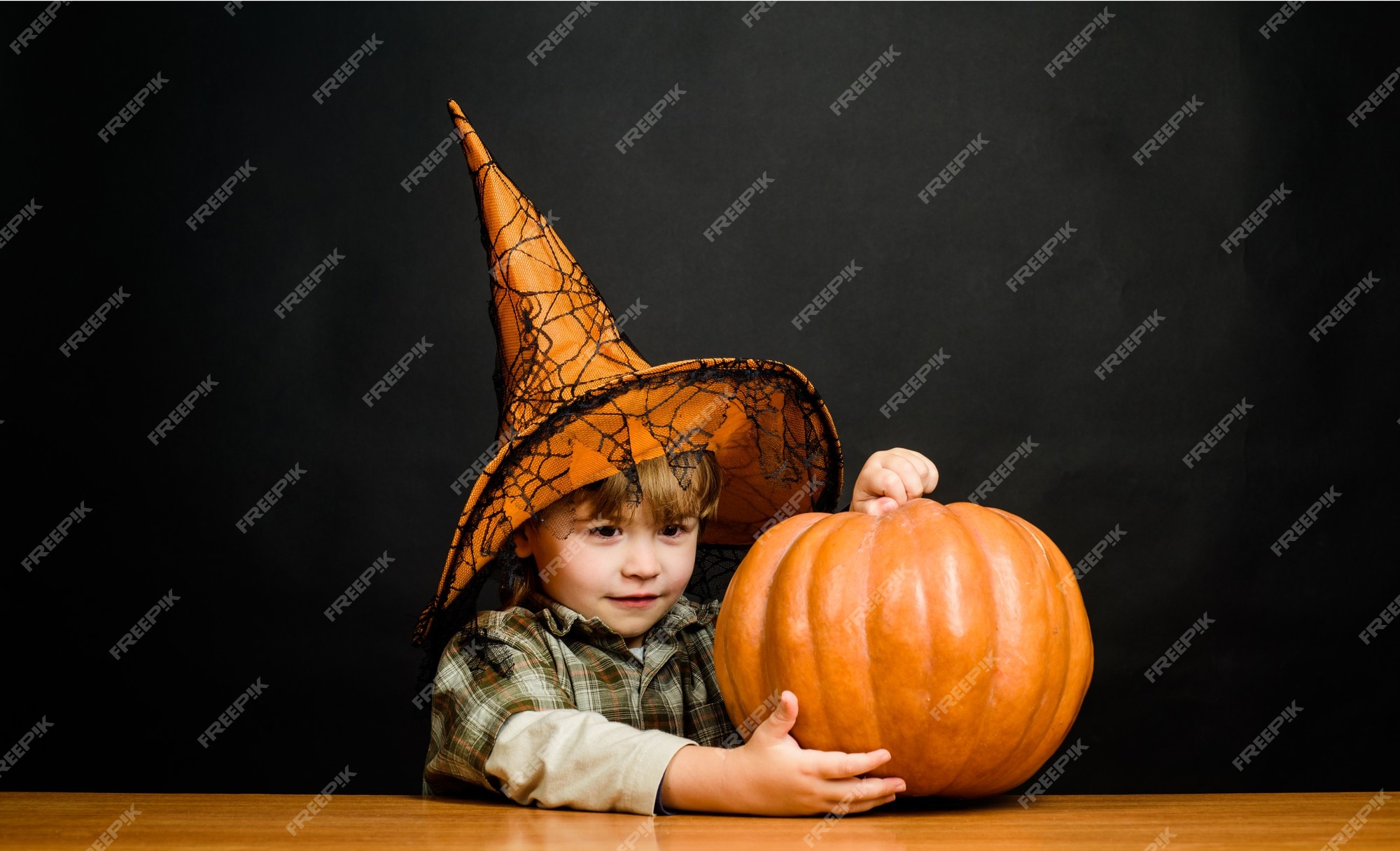 Crianças do dia das bruxas garotinho engraçado usando um chapéu de bruxa  com balões laranja e pretos feliz dia das bruxas