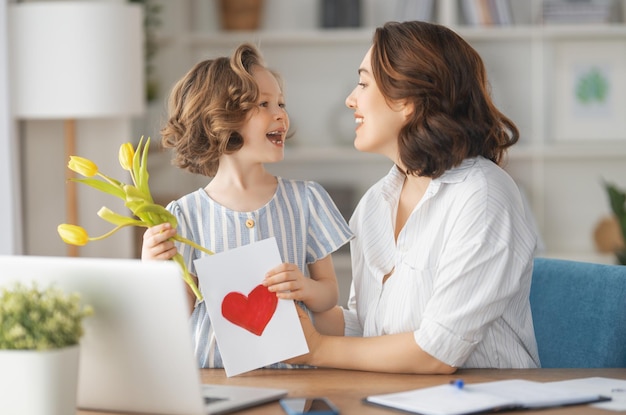 Feliz dia das mães Filha infantil parabenizando a mãe e dando-lhe flores