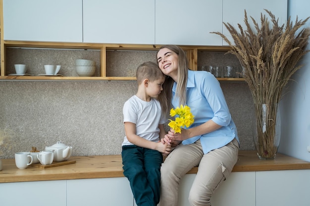 Feliz dia das mães filho dá flores para a mãe flores nas mãos de um menino 8 de março