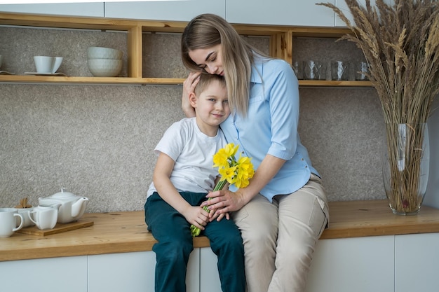 feliz dia das mães filho pequeno dá flores para a mãe menino felicita a mãe