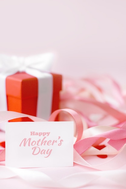 Feliz dia das mães ou dia da mulher Cartão branco em um fundo rosa com fitas festivas