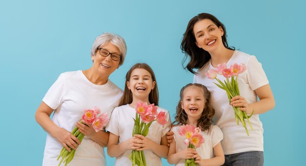 Feliz dia das mulheres As filhas das crianças estão parabenizando a mamãe e a vovó dando-lhes flores tulipas