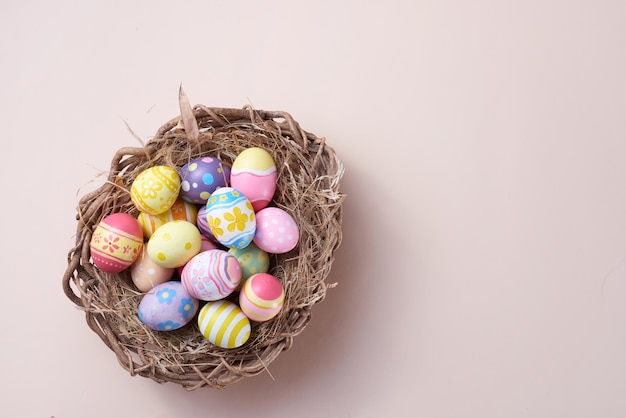 Feliz dia de páscoa ovos coloridos no ninho em fundo de papel com espaço de cópia
