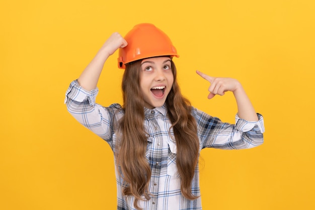 Feliz Dia do Trabalho. Carreira futura. menina adolescente no capacete. Construtor garoto com camisa quadriculada. edifício e conceito de construção. trabalhador criança surpreso apontando o dedo no capacete de segurança. desenvolvimento infantil.