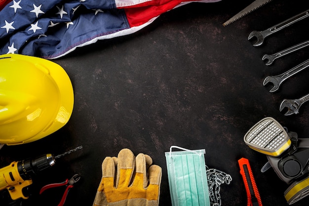 Foto feliz dia do trabalho vários engenheiros construtores de ferramentas de trabalho, máscara médica e bandeira americana