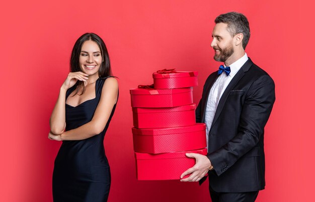 Feliz Dia dos Namorados Casal apaixonado isolado em vermelho Casal de aniversário com presente Homem amoroso dando caixa de presente para o Dia dos namorados para mulher surpreendida Homem recebendo presente Aniversário familiar