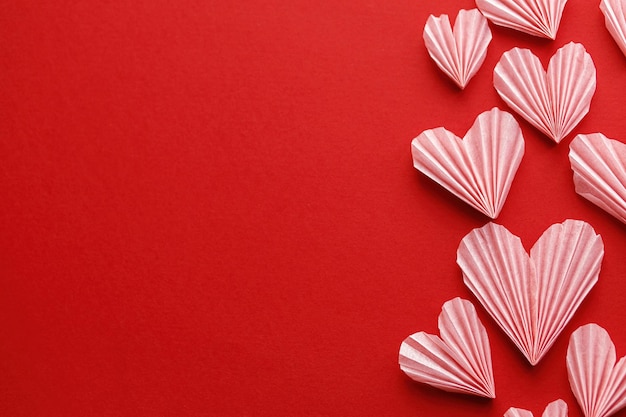 Feliz dia dos namorados Corações rosa elegantes em fundo de papel vermelho plano com espaço para texto Composição de recortes de coração de dia dos namorados fofos modernos Bandeira de amor criativa