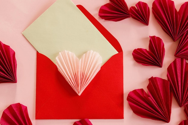 Foto feliz dia dos namorados envelope elegante com corações rosa e vermelhos planos sobre fundo de papel rosa recortes de corações modernos criativos para namorados espaço para cartas de amor para texto