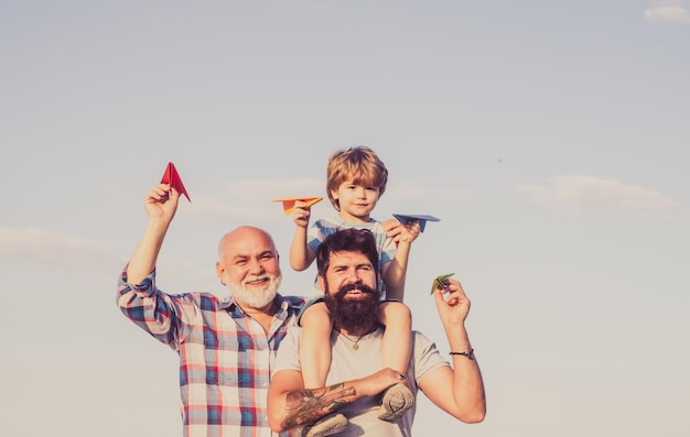 Foto feliz dia dos pais feliz três gerações de homens se divertem e sorriem no fundo do céu azul vovô