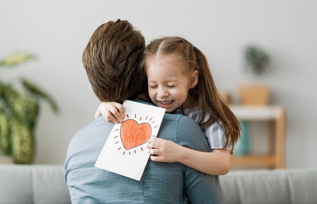 Feliz dia dos pais Filha infantil parabenizando o pai e dando-lhe cartão postal