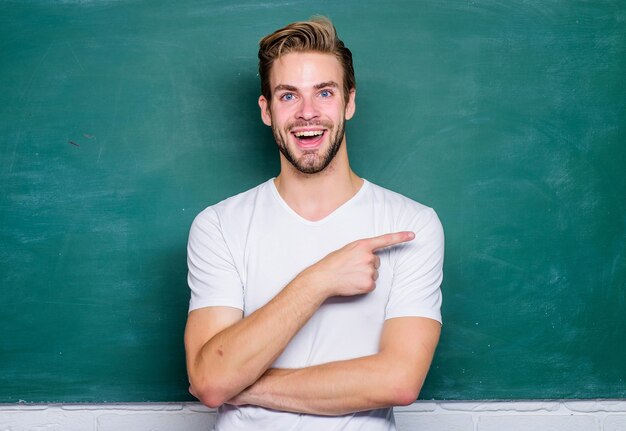 Feliz Dia dos professores. Mestre da simplificação. Professor de homem na frente do quadro-negro. As vantagens para o professor primário do sexo masculino são abundantes. Ensinar poderia ser mais divertido. Professor palestrante interessante.