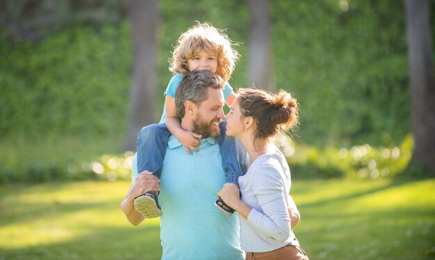 Feliz día de la familia Madre y padre cargando a su hijo sobre los hombros Día de la familia Padres e hijo